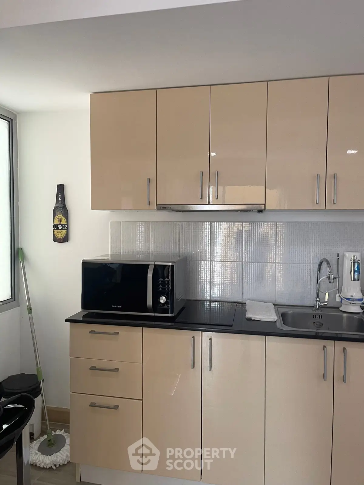 Modern kitchen with sleek cabinets and microwave, featuring a clean and minimalist design.