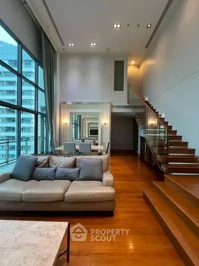 Luxurious modern living room with high ceilings and elegant staircase