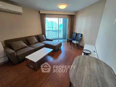 Spacious living room with modern furniture and balcony view in urban apartment.