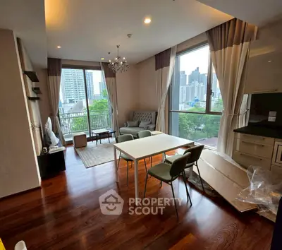 Spacious living room with large windows offering city views, elegant decor, and modern furnishings.