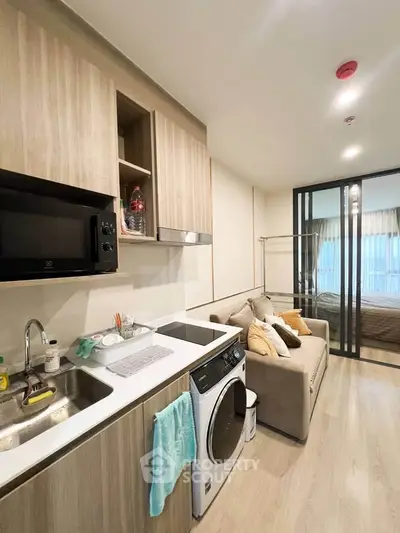 Modern studio apartment with compact kitchen and cozy living area