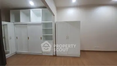 Spacious bedroom with built-in wardrobes and wooden flooring
