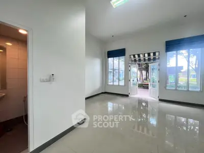 Spacious room with large windows and garden view, ideal for versatile use.