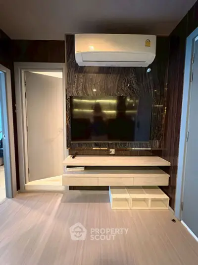 Modern living room with sleek TV setup and air conditioning unit
