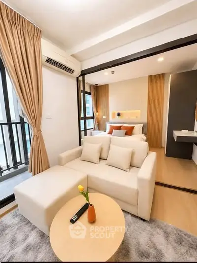 Modern studio apartment with cozy living area and stylish bedroom, featuring elegant decor and natural light.