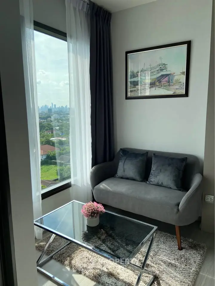 Charming living room with a stunning city view, featuring a cozy sofa and elegant decor.