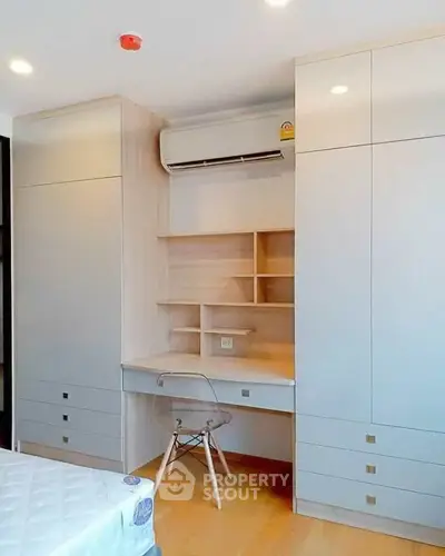 Modern bedroom with built-in desk and storage, featuring sleek design and efficient use of space.