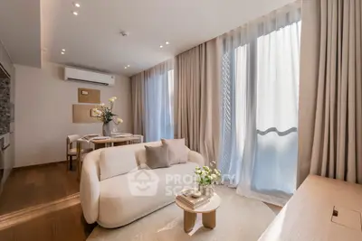 Elegant living room with modern decor, large windows, and cozy seating area in a stylish apartment.