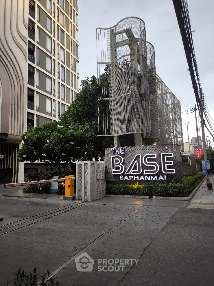 Modern urban apartment building entrance with stylish signage and lush greenery