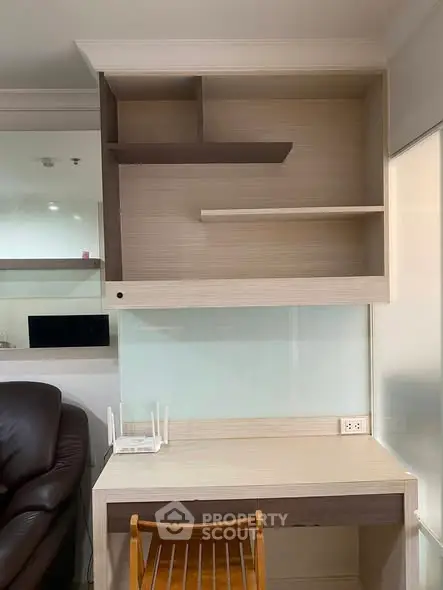 Modern study area with built-in shelves and wooden chair in a cozy apartment.