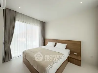 Spacious and bright bedroom with modern decor and large window