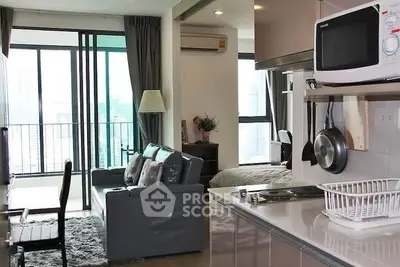 Modern open-plan living room with kitchen and balcony view in a high-rise apartment.