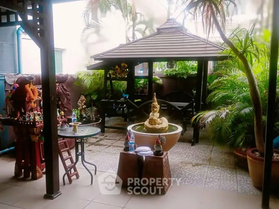 Charming garden patio with gazebo and lush greenery, perfect for relaxation and outdoor gatherings.