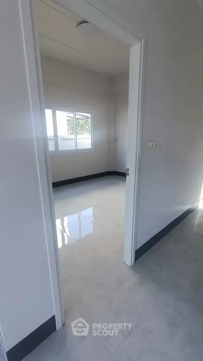 Spacious empty room with glossy tiled floor and large window