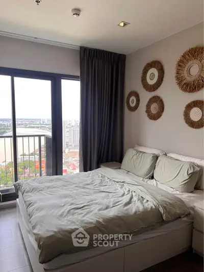 Modern bedroom with large window offering stunning city and river views, featuring stylish wall decor and cozy bedding.