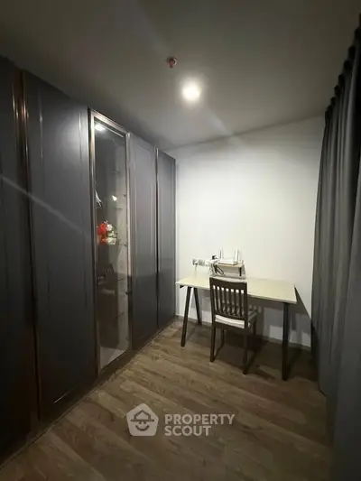 Cozy study room with elegant wooden flooring and sleek storage cabinets.
