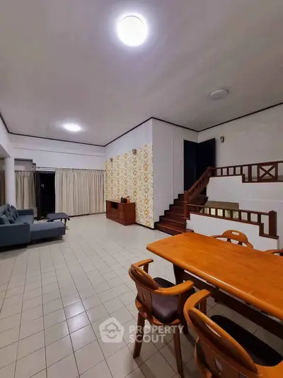 Spacious living room with modern furniture and stylish staircase in a cozy home.