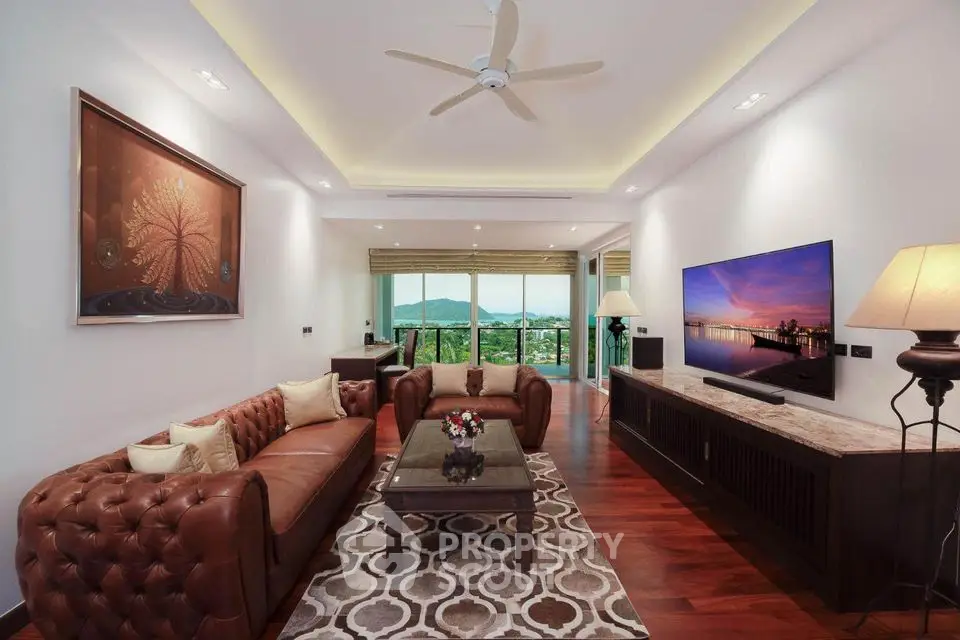 Luxurious living room with elegant decor and stunning view, featuring plush leather sofas and modern lighting.