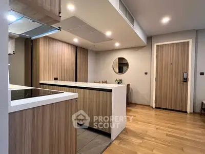 Modern kitchen with wooden cabinetry and sleek design in open layout apartment.