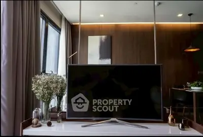 Modern living room with stylish decor and flat-screen TV, featuring elegant lighting and contemporary design.