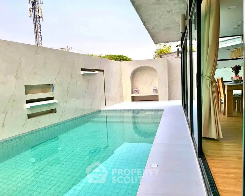 Luxurious modern home with private pool and elegant dining area, perfect for relaxation and entertainment.