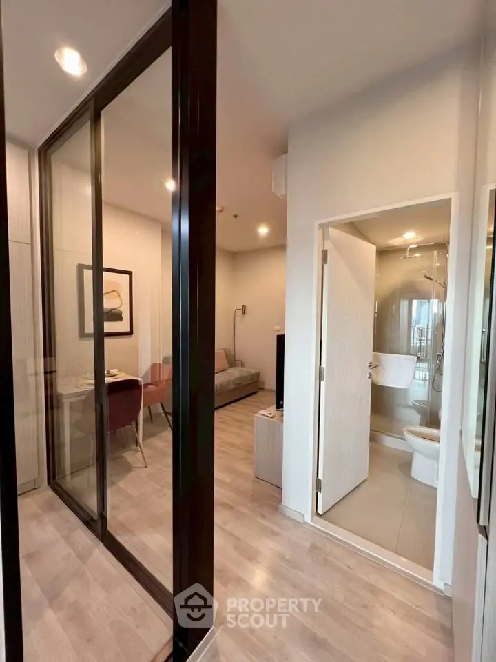 Modern apartment interior with open living and dining area, featuring sleek design and natural lighting.