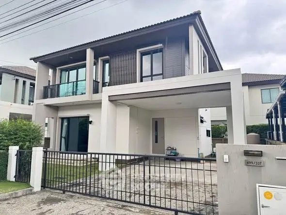 Modern two-story house with sleek design and spacious driveway in suburban neighborhood.
