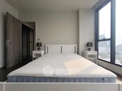 Modern bedroom with large windows and city view, featuring a minimalist bed and stylish nightstands.