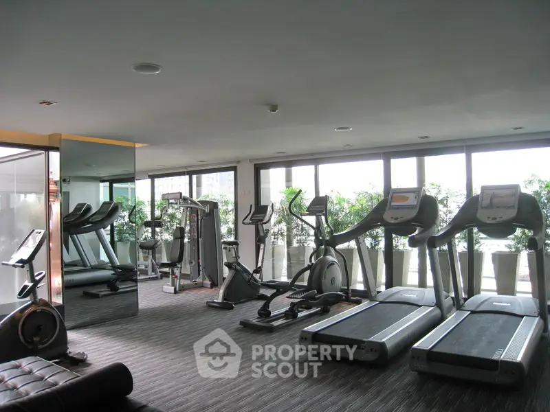 Spacious modern gym with treadmills and exercise bikes in a bright setting.