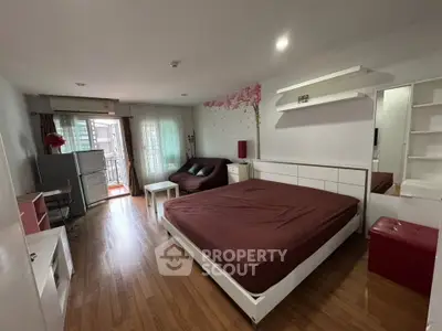 Spacious bedroom with modern decor and balcony access in a stylish apartment.