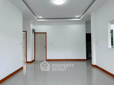 Spacious empty room with modern white walls and tiled flooring