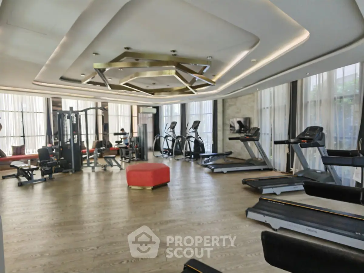 Luxurious gym with modern equipment and stylish design in upscale residential building.