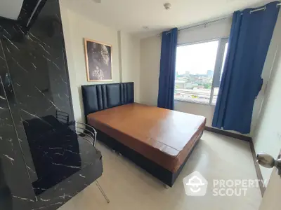 Spacious bedroom with large windows offering ample natural light and a stunning city view, complemented by elegant dark curtains and a sleek black feature wall.