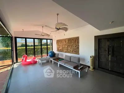 Spacious living room with modern decor and large windows opening to garden view.