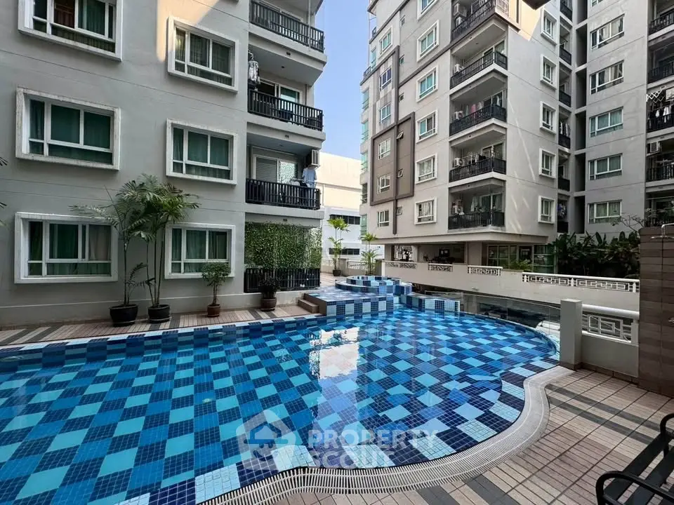 Modern apartment complex with a stylish outdoor pool and lush greenery.