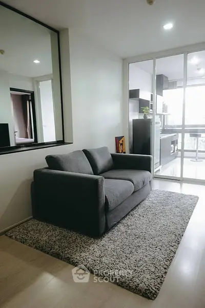 Modern living room with cozy gray sofa and stylish decor in a bright apartment.