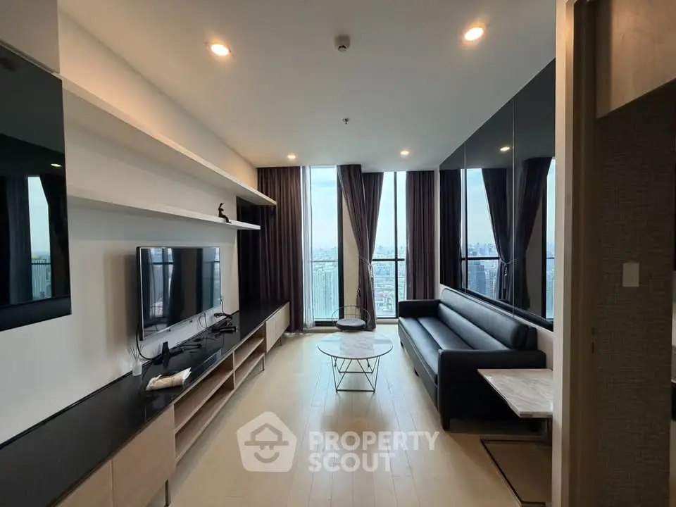 Modern living room with city view, sleek furniture, and floor-to-ceiling windows in a high-rise apartment.
