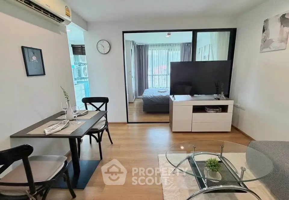 Modern open-plan living room with dining area and bedroom view