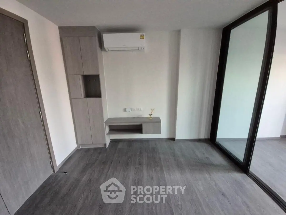 Modern empty room with sleek wooden flooring and built-in storage