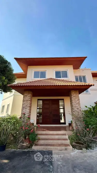 Stunning two-story home with elegant entrance and lush garden
