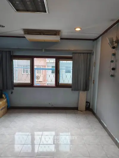 Spacious empty room with large windows and tiled floor, ideal for customization.