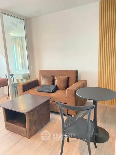 Modern living room with stylish brown sofa and sleek black table, perfect for cozy relaxation.