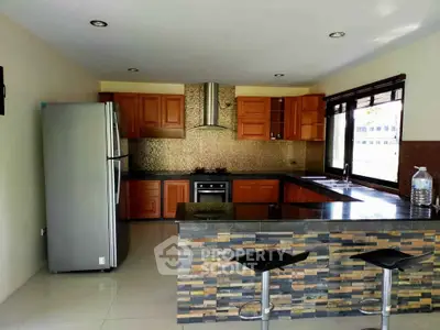 Modern kitchen with sleek appliances and stylish stone island in a spacious open layout.