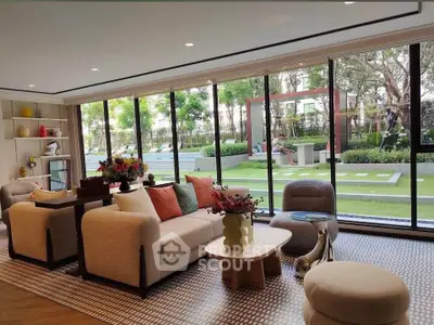 Luxurious living room with large windows overlooking a lush garden, featuring modern furniture and elegant decor.