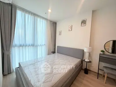 Modern bedroom with large window, stylish decor, and cozy ambiance in a contemporary apartment.