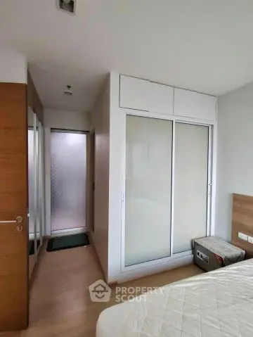 Modern bedroom with sliding closet doors and wooden flooring
