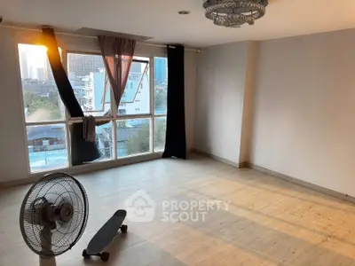 Spacious empty room with large window and city view, ideal for customization.