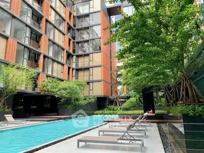 Luxurious modern apartment complex with stunning outdoor pool and lush greenery.