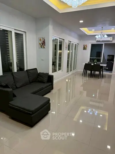 Modern living room with sleek black sofa and elegant dining area
