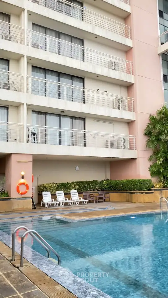Luxurious apartment building with inviting pool and relaxing lounge area.